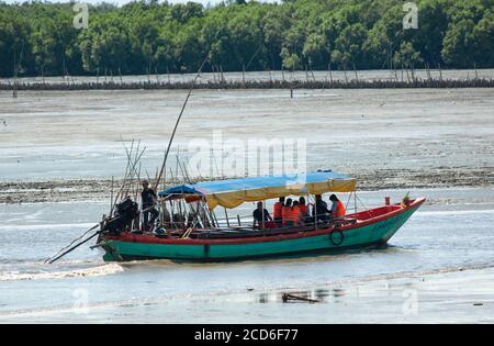 Barca turistica a coda lunga su un canale dragato tra le rive di fango nella provincia di Chachoengsao in Thailandia. Mangrovie foresta sullo sfondo. Foto Stock