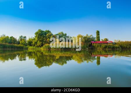 Case di legno e case tra gli alberi sul lago a Varazdin, Croazia rurale Foto Stock