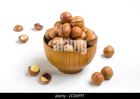 noci di macadamia naturale organica in ciotola di legno su cemento grigio Sfondo Flat Lay Top vista snack sani noci con essenziale Olio ricco di vitamine B. Foto Stock