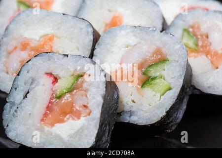 Il sushi rotola il Futo Maki su sfondo nero. Foto Stock