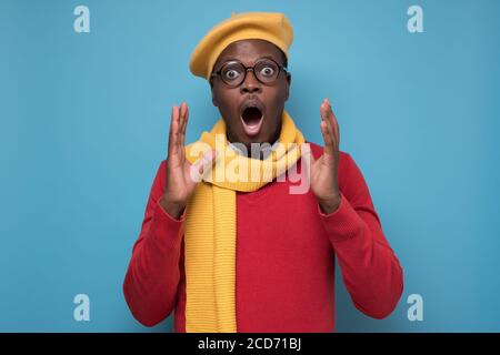 uomo africano urlando nello shock, tenendo la bocca aperta, sentendosi eccitato Foto Stock