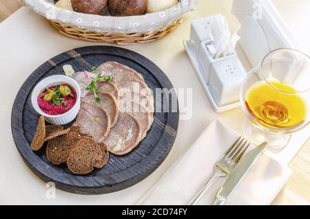Snack dalla lingua con crostini e rafano su un sfondo chiaro Foto Stock