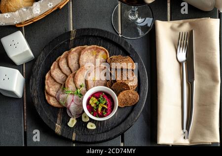 Snack dalla lingua con crostini e rafano su un sfondo scuro Foto Stock