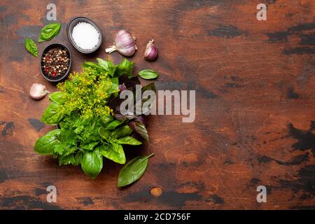 Ingredienti della cucina. Varie erbe e spezie. Basilico, aneto, prezzemolo e aglio Vista dall'alto con spazio per le copie. Disposizione piatta Foto Stock