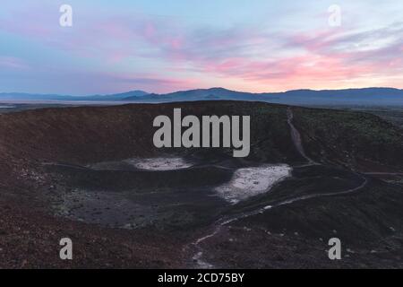 Crepuscolo colorato sopra un cratere Amboy con cono di scorie in California Foto Stock