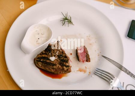 Un pezzo tagliato di bistecca con sangue su un piatto. Foto Stock