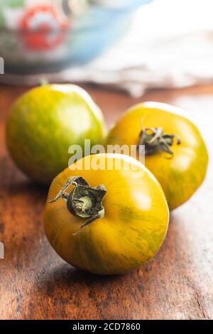 Pomodori zebra verdi su tavolo di legno. Foto Stock