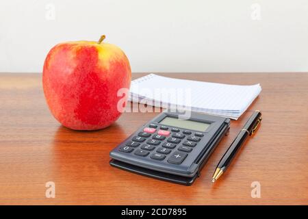 La calcolatrice del blocco note della penna Apple si trova sul tavolo. Foto Stock