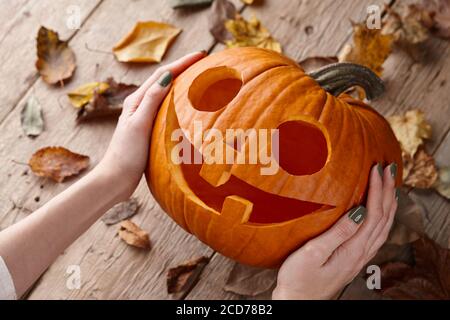 Donna che tiene cric di zucca scolpito per la vacanza di Halloween, vista ravvicinata Foto Stock