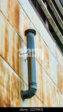 Tubo di scarico sul vecchio edificio Foto Stock