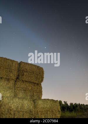 Scena notturna a lunga esposizione di pile di fieno quadrate isolate su un Fattoria rurale campo- Israele Foto Stock