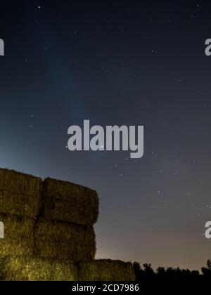 Scena notturna a lunga esposizione di pile di fieno quadrate isolate su un Fattoria rurale campo- Israele Foto Stock