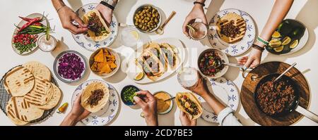 Amici che hanno una cena Taco in stile messicano con birra e spuntini Foto Stock