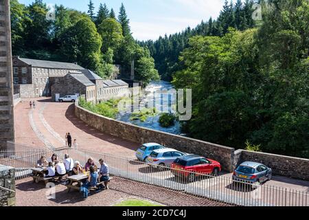 I visitatori potranno godersi il sole estivo al New Lanark, sito patrimonio dell'umanità, a New Lanark, Lanarkshire, Scozia, Regno Unito Foto Stock