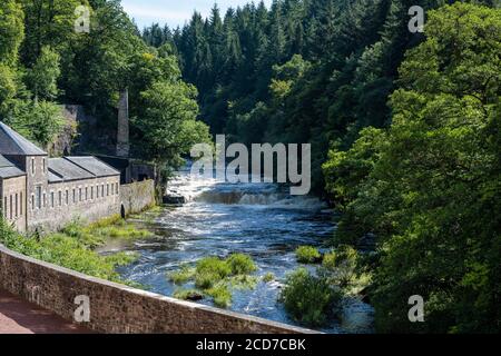 Ex tintura accanto al fiume Clyde con la cascata Dundaff Linn oltre a New Lanark, sito patrimonio dell'umanità, New Lanark, Lanarkshire, Scozia, Regno Unito Foto Stock