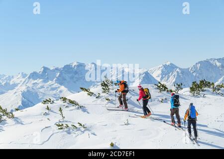 Un gruppo di scialpinisti che salgono in cima alla montagna alpi austriache in una giornata di sole Foto Stock