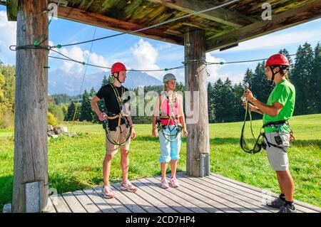 I giovani a fare gli esercizi in alta fune corso in una giornata di sole Foto Stock