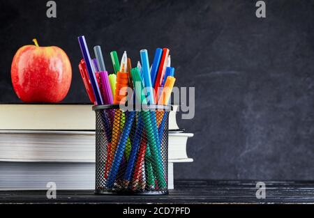 Ritorno a scuola con libri e mela su lavagna con spazio di copia. Concetto di ritorno a scuola Foto Stock