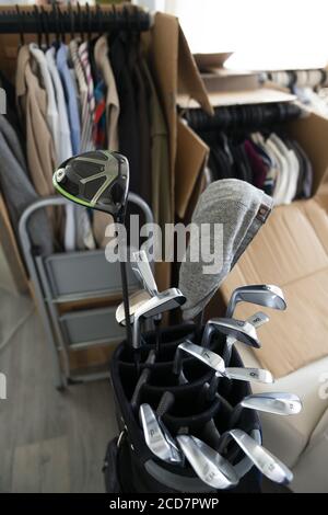 Mobile House con scatole di cartone e vestiti e Golf Bag con Golf Club in soggiorno in Svizzera. Foto Stock