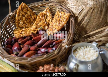 Cibi tipici. Feste di São João. Prelibatezze del mese di giugno. Arachidi, mais verde, popcorn, pinoli e hominy. Divertimento popolare. Rapadura in Foto Stock