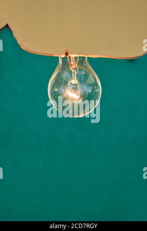 primo piano di un'immagine in bianco e nero di un lampadina elettrica vecchio stile accesa sotto un oro e tettoia verde Foto Stock
