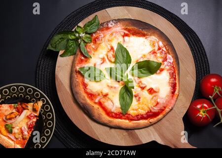 Concetto di cibo pizza casalinga Tortilla Margherita su tavola di legno sfondo nero con spazio per la copia Foto Stock