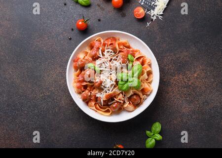 Fettuccine di pasta italiana con polpette, parmigiano, pomodori, basilico. Vista dall'alto. Foto Stock