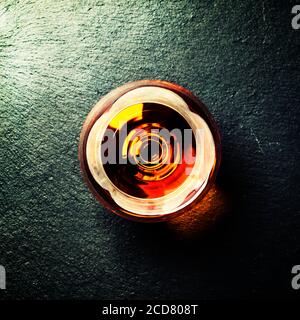 Cognac in un vetro su sfondo di pietra nera, vista dall'alto Foto Stock