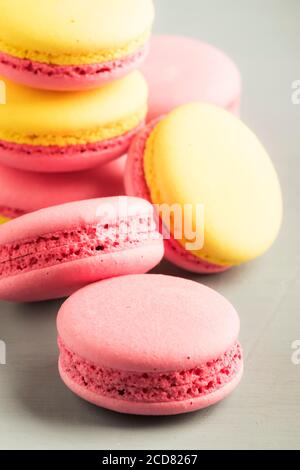 Macaroon giallo rosa torte su sfondo grigio tavolo, posto per il testo, stile minimalismo alla moda, fuoco selettivo Foto Stock