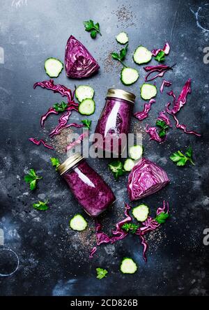 Smoothies disintossicazione sano e utile o succo di cavolo rosso, cetrioli con semi di chia in bottiglie di vetro su uno sfondo grigio, vista dall'alto Foto Stock
