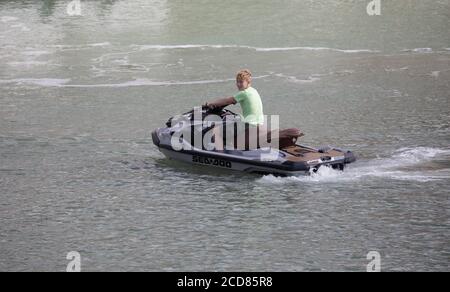 Un giovane ragazzo guida un jetski seadoo nella Marina di Brighton, Sussex orientale Foto Stock