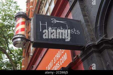 Barbiere e parrucchiere segno negozio. Londra Foto Stock