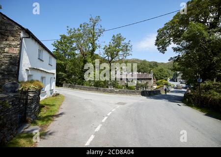 mill race cottage e strada attraverso il ponte elterwater in il villaggio di elterwater lake district inghilterra uk Foto Stock