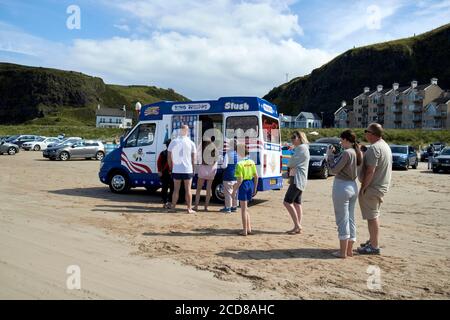 la gente fa la fila per il gelato al pulmino icecream in discesa spiaggia di benone durante la contea estiva londonderry irlanda del nord Foto Stock