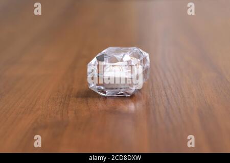 Una scatola di cristallo con anelli di nozze su un tavolo di legno Foto Stock