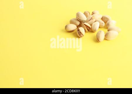 Primo piano di pistacchi su sfondo giallo Foto Stock