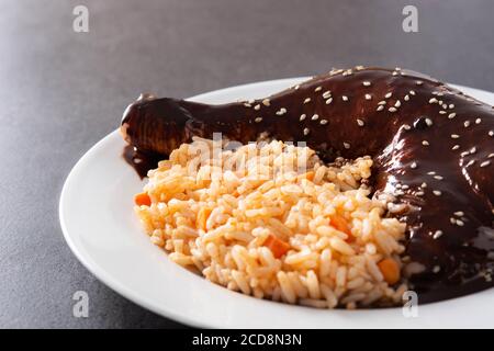 Tradizionale mole Poblano con riso in piastra su ardesia nera sfondo Foto Stock