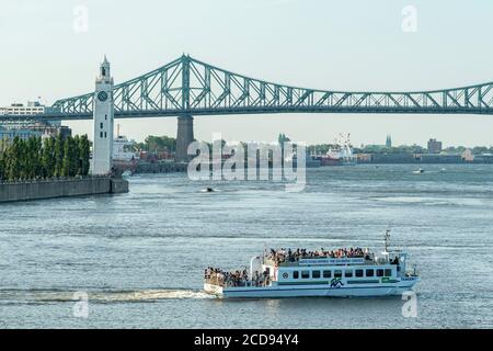 Canada, Quebec, Montreal, una navetta fluviale sul fiume San Lorenzo, la Torre dell'Orologio e il Ponte Jacques Cartier sullo sfondo Foto Stock