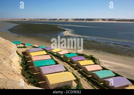 Marocco, Sahara occidentale, Dakhla, tetti colorati dell'hotel PK25 di fronte alla laguna e le montagne del deserto Foto Stock