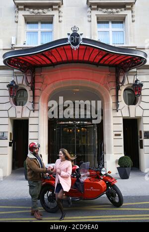 Hotel France, Paris, Royal Monceau, donna che guida in un'auto retrò di fronte alla facciata dell'hotel sorvegliata da due camerieri Foto Stock