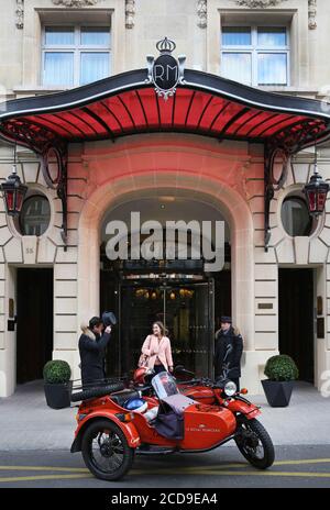 Hotel France, Paris, Royal Monceau, donna che guida in un'auto retrò di fronte alla facciata dell'hotel sorvegliata da due camerieri Foto Stock