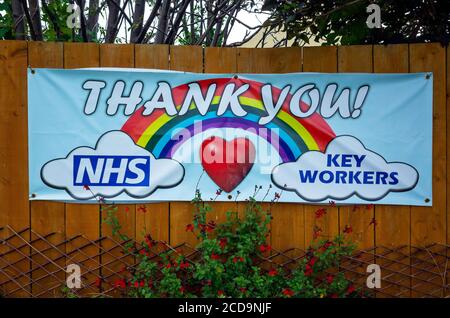 Un avviso colorfull attaccato ad una recinzione del giardino con un rainbow un cuore e un testo grazie NHS lavoratori chiave Foto Stock