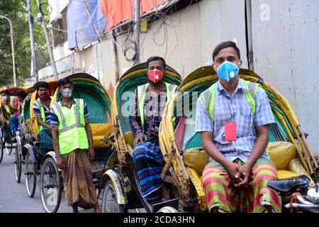 I conducenti del Bangladesh Rickshaw attendono i passeggeri durante un blocco imposto dal governo come misura preventiva contro il coronavirus COVID-19 a Dhaka, B. Foto Stock