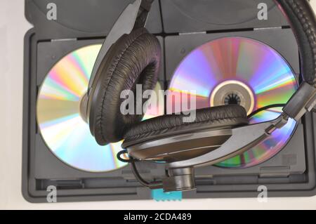 Cuffia e CD Compact Disc in custodia termica bianca vista dall'alto sullo sfondo e coperchio in acrilico Foto Stock