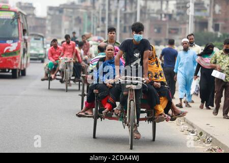 Dhaka, Bangladesh. 27 Agosto 2020. La gente del Bangladesh prende un giro su un furgone di risciò senza mantenere la distanza sociale fra loro malgrado i rischi di infezione da coronavirus (COVID-19), a Dhaka, Bangladesh, 27 agosto 2020. In base alle statistiche elaborate dal sito di riferimento della corona globale, il Bangladesh ha registrato un tasso di mortalità del 1.3 per cento, uno dei più bassi del mondo, contro una media globale del 3.54 per cento. Credit: Suvra Kanti Das/ZUMA Wire/Alamy Live News Foto Stock