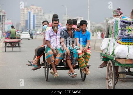 Dhaka, Bangladesh. 27 Agosto 2020. La gente del Bangladesh prende un giro su un furgone di risciò senza mantenere la distanza sociale fra loro malgrado i rischi di infezione da coronavirus (COVID-19), a Dhaka, Bangladesh, 27 agosto 2020. In base alle statistiche elaborate dal sito di riferimento della corona globale, il Bangladesh ha registrato un tasso di mortalità del 1.3 per cento, uno dei più bassi del mondo, contro una media globale del 3.54 per cento. Credit: Suvra Kanti Das/ZUMA Wire/Alamy Live News Foto Stock