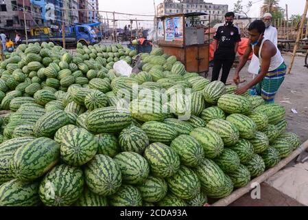 Il fornitore di angurie del Bangladesh attende il cliente in un mercato della cucina durante il governo ha imposto lo spegnimento come misura preventiva contro COVID-19 Foto Stock