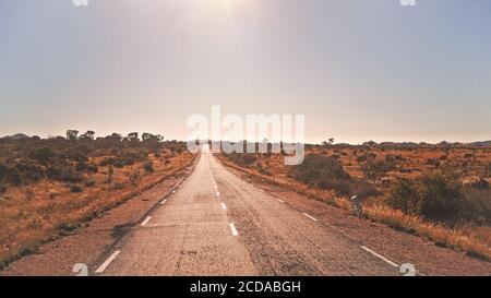 Leggendaria RN7 - sta per Route Nationale - strada che attraversa la selvaggia savana africana rossa con piccoli alberi e cespugli sui lati, nella regione vicino Ilakaka, Foto Stock