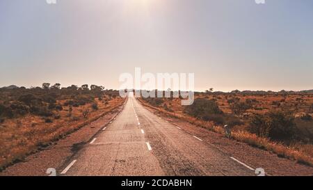 Leggendaria RN7 - sta per Route Nationale - strada che attraversa la selvaggia savana africana rossa con piccoli alberi e cespugli sui lati, nella regione vicino Ilakaka, Foto Stock