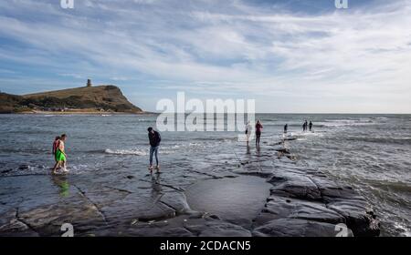 Kimmeridge Bay Seascape con persone su affioramento roccioso nel mare e la Clavell Tower a Kimmeridge, Isola di Purbeck, Dorset, Regno Unito il 26 agosto 2020 Foto Stock